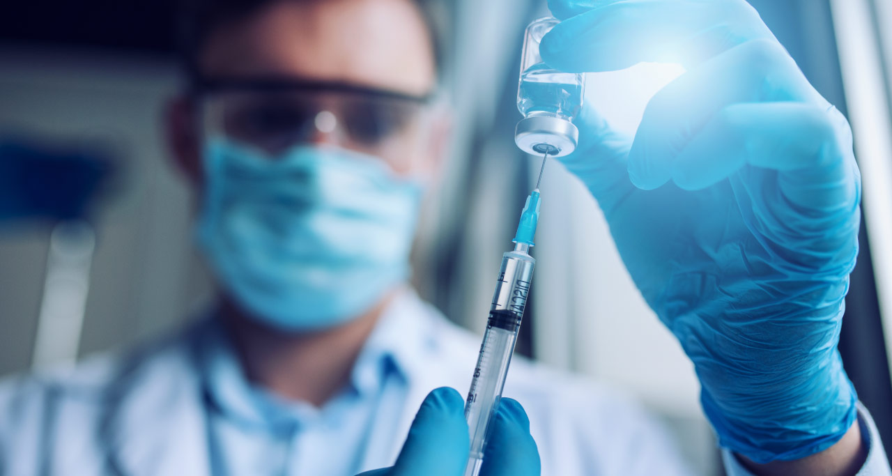 Médico usando uma seringa para extrair a cetamina da ampola.